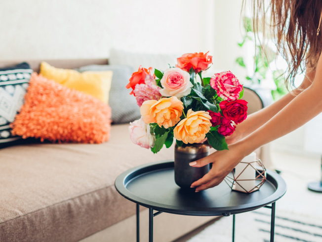 Woman with flowers in home.